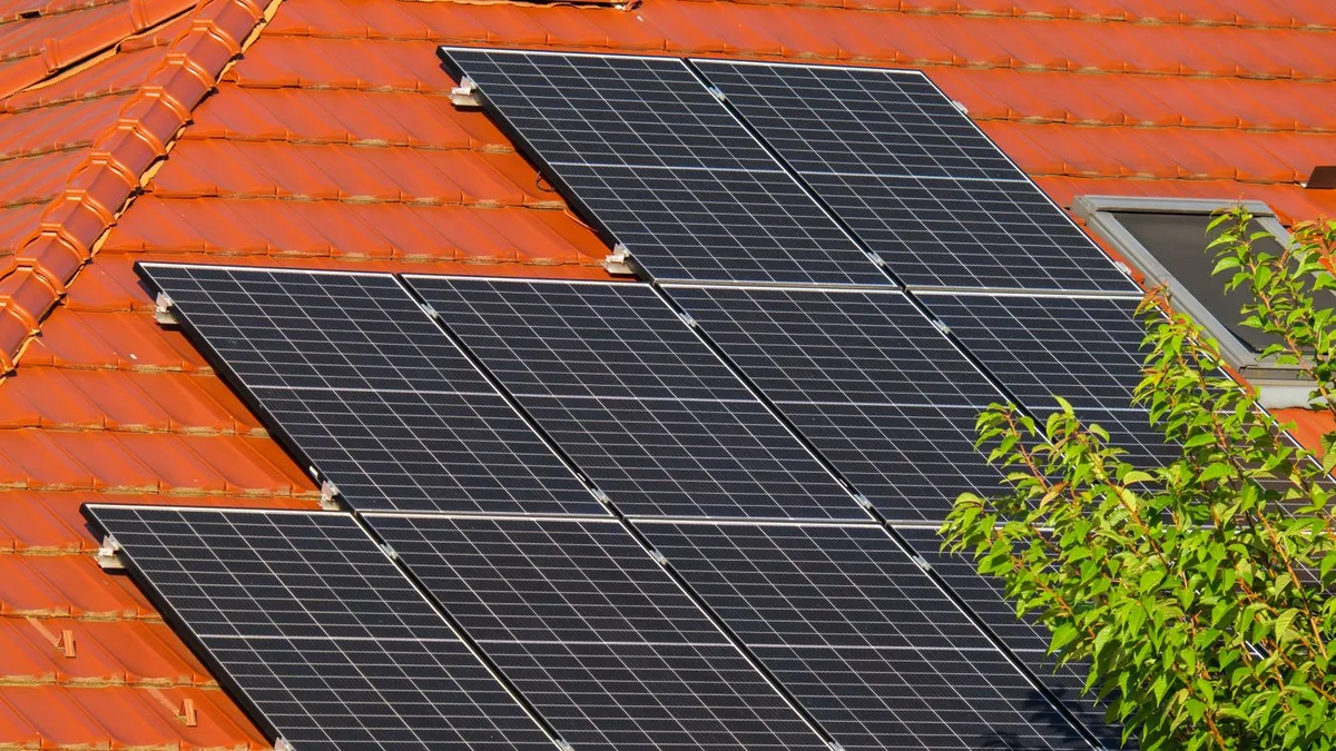 Panouri fotovoltaice montate pe acoperiș din țiglă roșie, pentru autoconsum