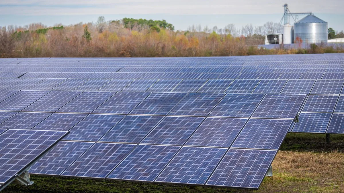 Parc fotovoltaic cu rânduri de panouri montate pe sol, într-o zi de toamnă